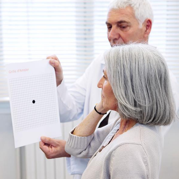 A doctor holds a glaucoma chart up for an elderly woman to check her eyesight.