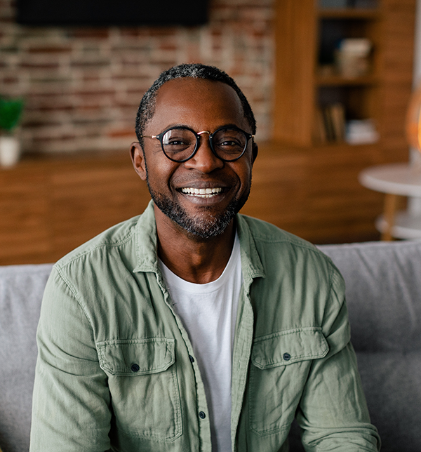 Man wearing glasses smiles for camera.