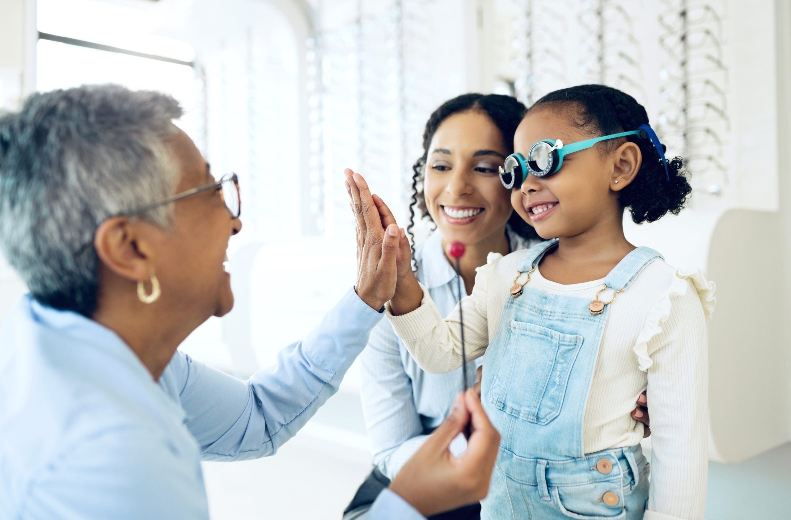 Kid with new glasses high-fiving parents.