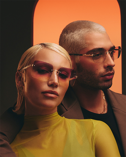 A man and a woman with blonde hair pose together modeling Barton Sunglasses.