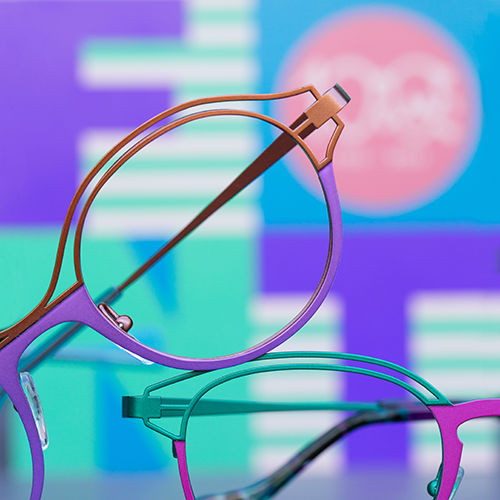 Two pastel colored pairs of Lafont Oeillet glasses with a pastel colored background.