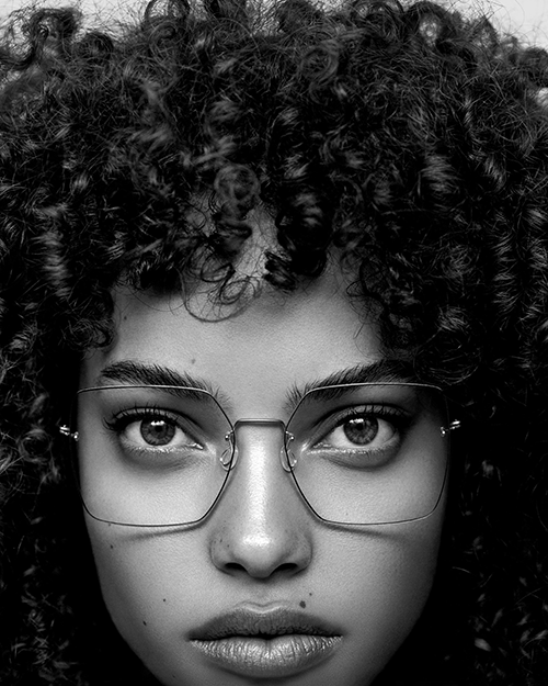 A black woman models Lindberg glasses.