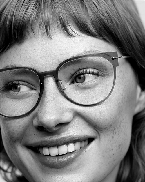 A white woman models Lindberg glasses.